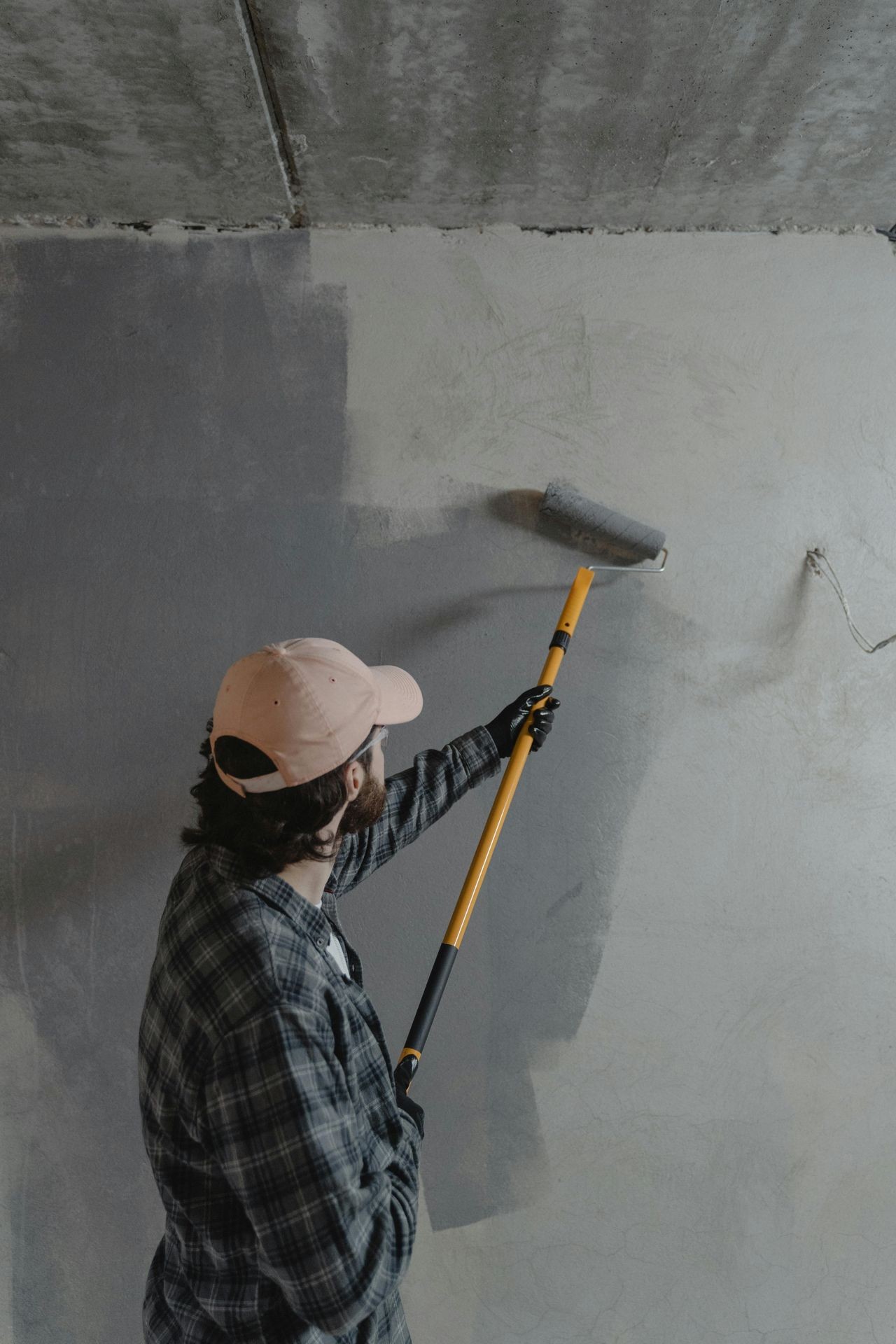 Professional contractor painting an exterior wall during home renovation